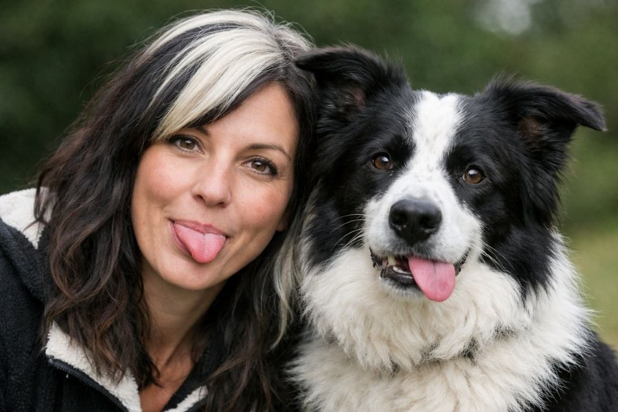A woman with a black and white border collie who has similar hair reflecting her pooch personality
